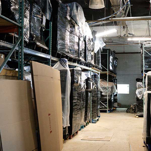 A long warehouse aisle of shrink-wrapped goods on pallet racking